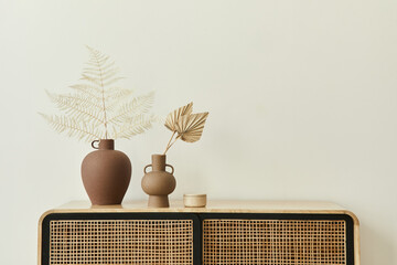Modern scandinavian home interior with design wooden commode, dried leafs in ceramic vases and...