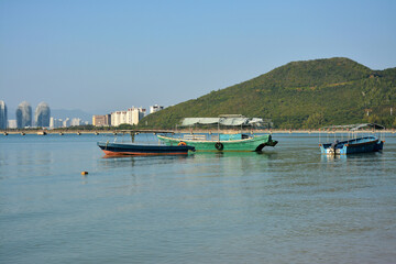 Fototapeta na wymiar few fishing boats park at the peaceful sea harbor in sunny day