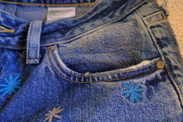 blue jeans with zipper, pocket, metal button, jeans details close-up. denim background. Casual...