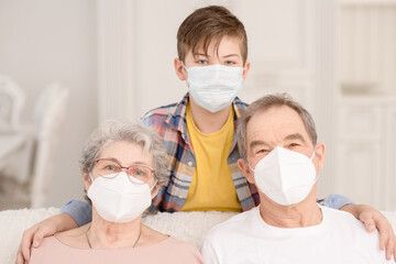 Portrait of a family during the coronavirus pandemic. Old people in medical masks communicate with a child at home