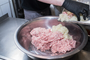 The chef mixes minced pork with different ingredients