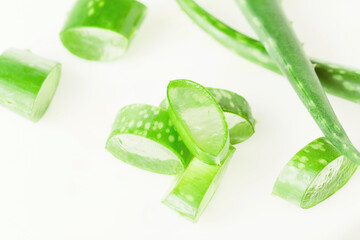 Green fresh aloe vera leaves and slices on white background. Top view. Flat lay.