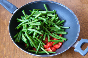 Italian recipe: farm fresh green beans with little tomatoes in a wok