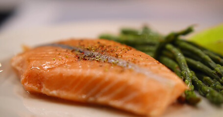 Fresh boiled asparagus and baked salmon steak with dressing sauce on plate