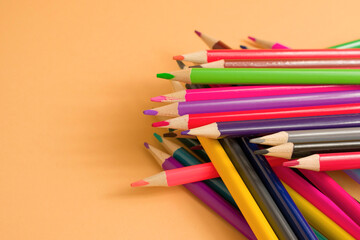 Close-Up Of colored pencil placed on yellow paper background with copy space for your image or text