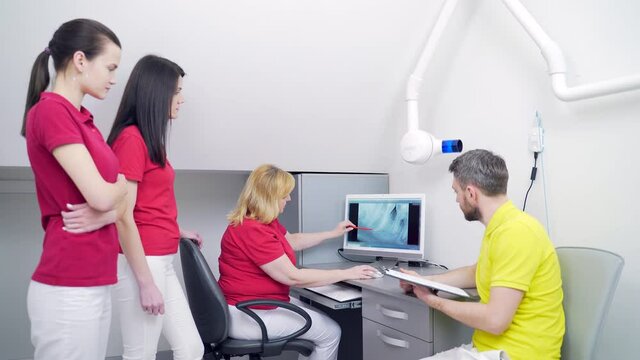 Medical dentist team in dental office discuss and examining x-ray image. looking at computer Desktop screen in modern dental clinic x-ray room In Hospital 