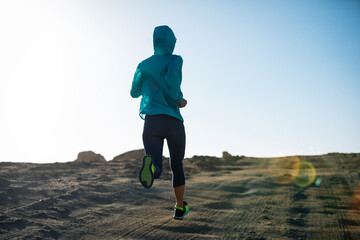 Fitness woman trail runner cross country running  on sand desert