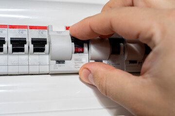 A closeup of an electrical engineer working in a power electrical panel in apartment building. Check the parameters of the power plant.