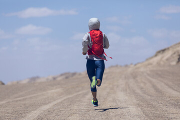 Fitness woman trail runner cross country running on sand desert