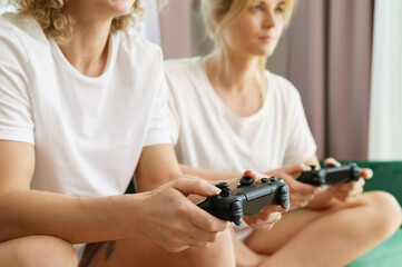 Two girls playing video game console in living room
