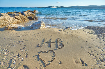 J plus B with heart written on sandy beach in Croatia