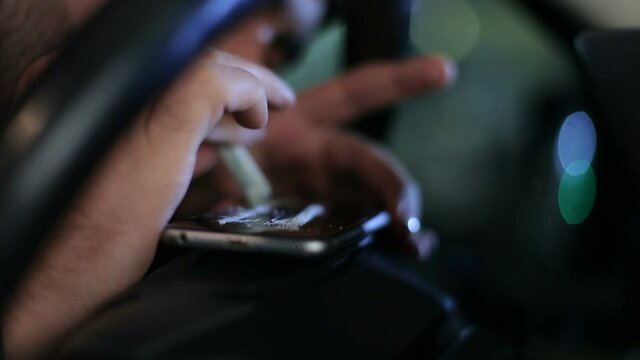 Man in the car Sniffing the cocaine lines with a dollar bill, in background glare multi color of light of cars