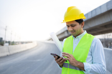 asian man architect using smartphone at construction site