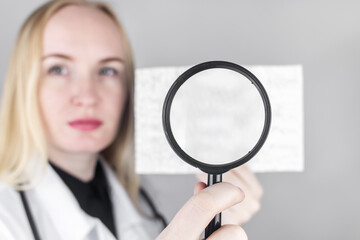 A neurologist with a magnifying glass examines an encephalogram of a patient’s brain. Schedule of...