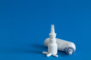 FFP3 mask, nasal drops, thermometer, tablets, various medicines lie on the table, top view, on a blue background