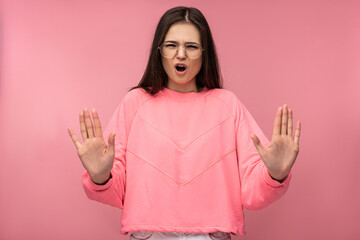 Photo of attractive young woman in glasses shows dislike and disagree with something. Wears casual...