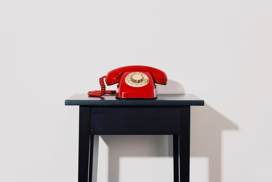 red telephone on a black table