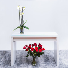 Jarrón con rosas bajo la mesa y Orquídeas sobre la mesa.