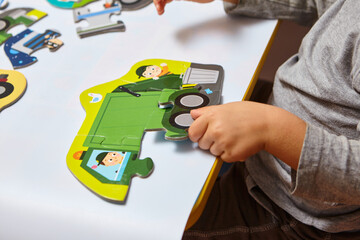Child playing with puzzles,. The boy is playing in his room. Educational logic toys for kid's..