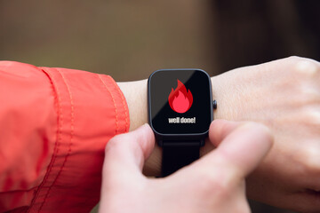 smart watch worn on the wrist seen up close with the calorie symbol