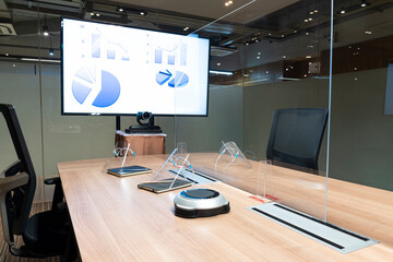 Video conference meeting room with clear acrylic sheet separates the center on the conference table...