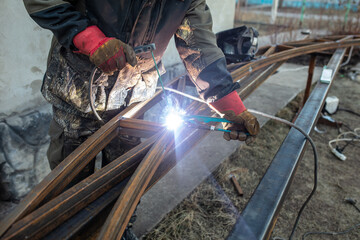 A worker welds metal for a canopy.