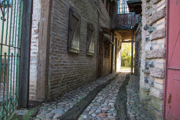 Pasillo empedrado con edificios antiguos de estilo colonial