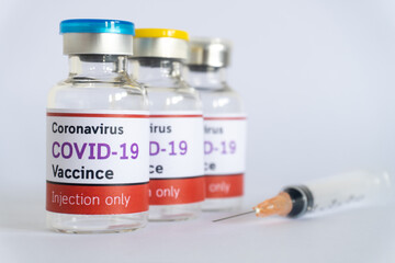 Bottles of vaccine COVID-19 virus with syringe on white background