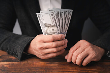 Business executive in formal suit Holding money that is a bribe In order to offer bad business...