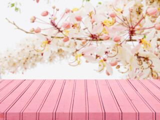 Naklejka na ściany i meble Pink wooden floor to place products online. Concept of wooden floor for sale, Blurred background of pink flowers in the concept of selling cosmetics for sale or products Valentine's day.
