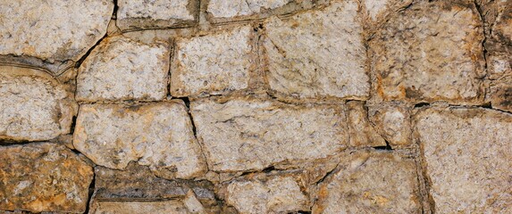 Natural old beige stone wall textured banner. Close up. Copy space.	
