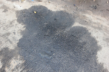 Black engine oil on concrete floor. Engine oil leak from the engine