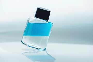 A cosmetic glass bottle of liquid with layers of alcohol and oil, in a state of floating...