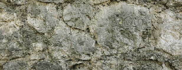 Natural old beige stone wall textured banner. Close up. Copy space.	