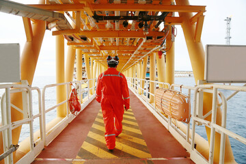 Offshore oil and gas industry and operated by technician petroleum. Worker walking to oil and gas...