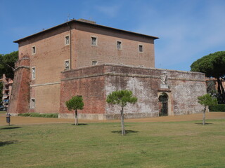 Fototapeta na wymiar San Rocco Fortress in Marina di Grosseto, a bastion with the entrance door and the Lorraine coat of arms, situated on a green lawn.
