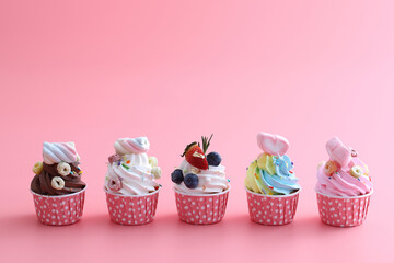 Colorful cupcakes isolated in pink background