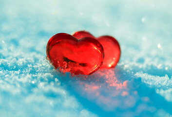 Fototapeta premium valentine's day greeting card with festive background with two transparent red love symbols hearts on blue snow