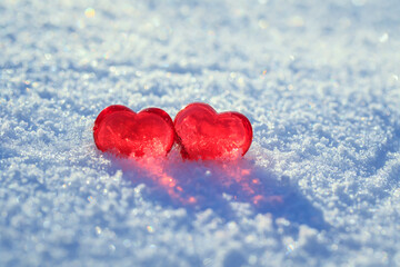 Fototapeta premium valentine's day greeting card with festive background with two transparent red love symbols hearts on the snow