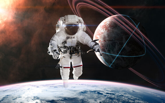 Astronaut on background of planets in deep space. Glowing structures on surface of planet with rings. Science fiction. Elements of this image furnished by NASA