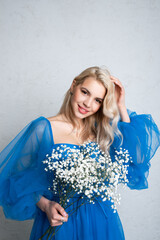 Beautiful girl in a dress with flowers on a white background