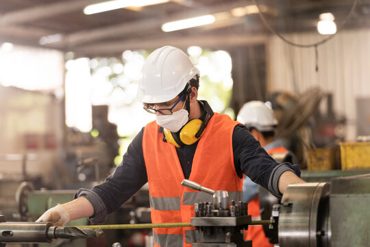 Workers Factory Man Wearing Face Mask And Working At Heavy Machine. Safety Protection Of Air Pollution Smoke Dust And Disease Virus Covid 19. New Normal Life In Workplace.