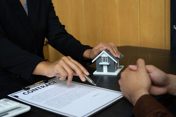 The house plan with the real estate agent and the client is signing a purchase agreement. And...