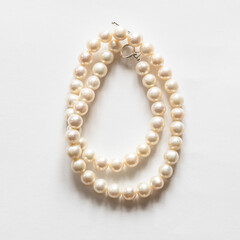 folded natural white pearl necklace on white background