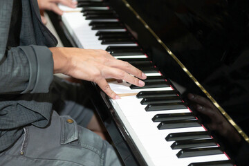Fototapeta na wymiar The hand that is playing the piano keys