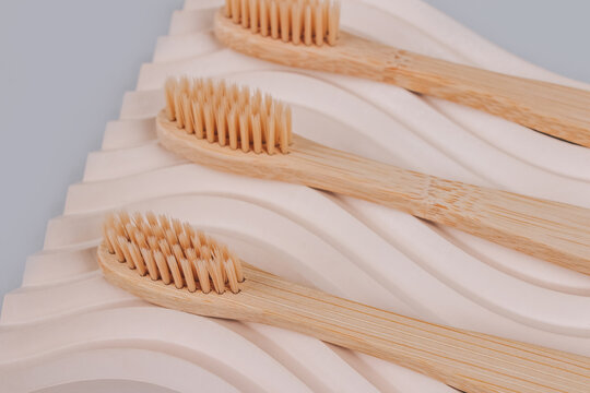 Still life composition with natural bamboo toothbrushes on trendy plaster molds background with copy space. Close up view. Sustainable lifestyle, bathroom essentials, zero waste home. Selective focus