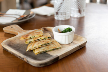 Crispy pizza on wooden plates with sauce cups