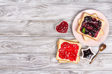 Delicious toasts with various sweet jams on grey background. Copyspace for your text, banner.