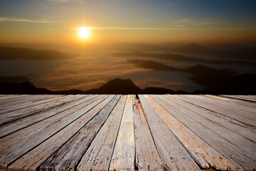 Fototapeta na wymiar An empty wooden terrace with mountain view and mist during sunrise.