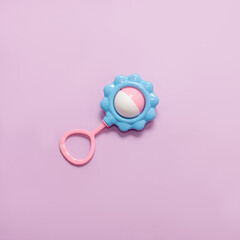 Baby rattle on purple background